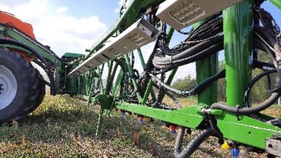 Intelligente Feldspritze in der der Seitenansicht montiert an einen Traktor.