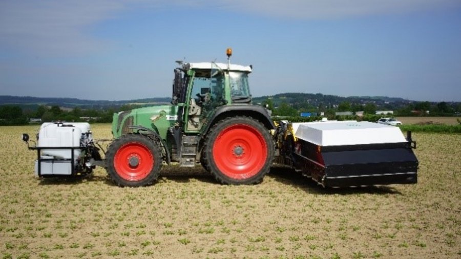 Ein Traktor mit Präzisionsfeldspritze auf einem Acker mit Zuckerrüben.